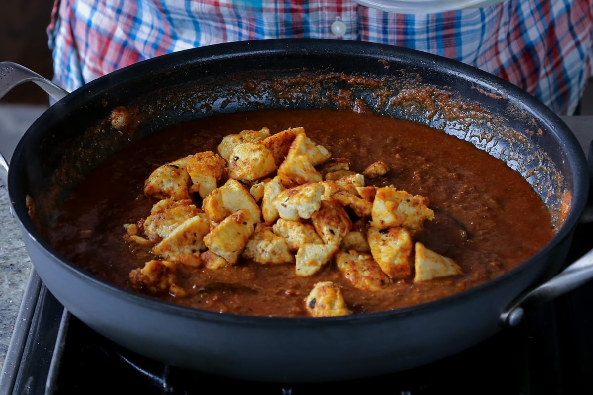 adding tofu to the Malvani curry sauce