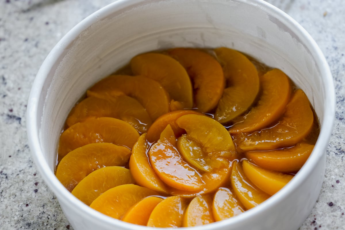 peaches layered into the bottom of the cake pan
