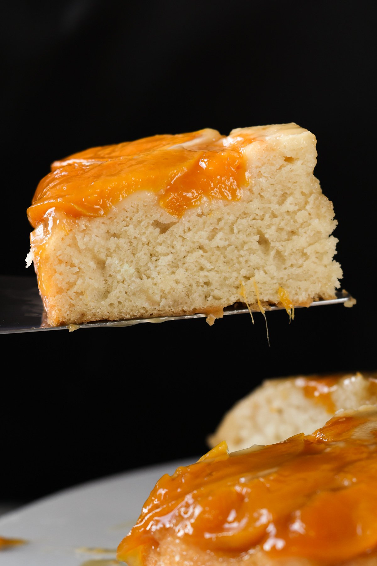 serving a slice of peach upside-down cake