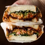 hand holding a gochujang chickpea salad sandwich