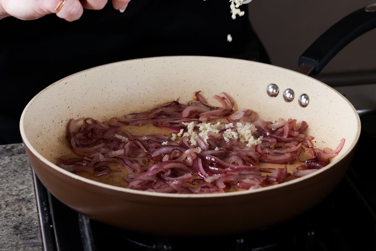 adding the garlic to the partially cooked onions