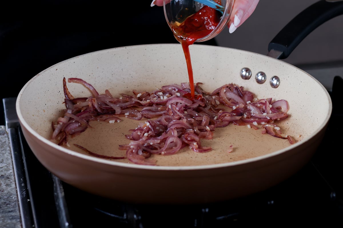 adding gochujang to the partially cooked onions