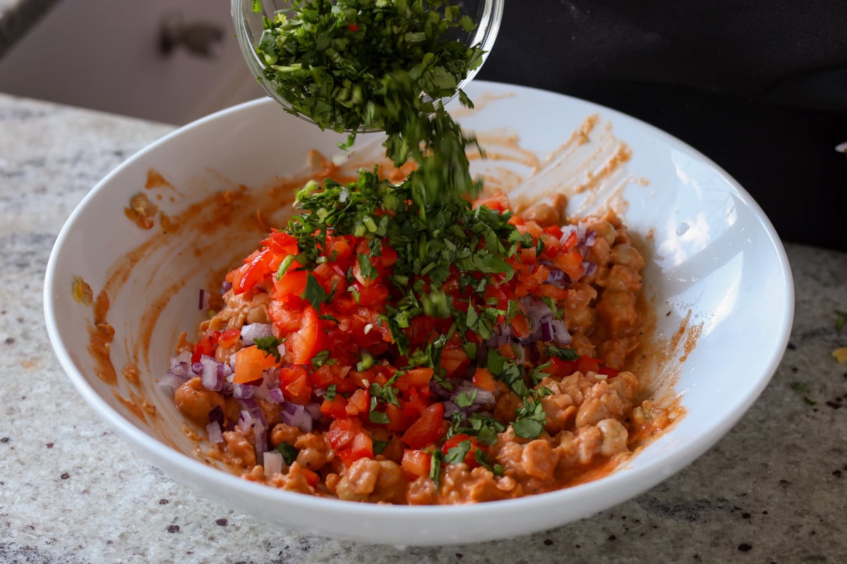 adding cilantro to the gochujang chickpea salad