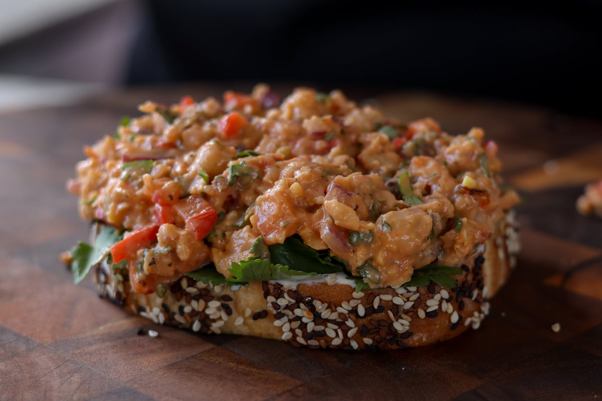 topping the cilantro on the bread with gochujang chickpea salad