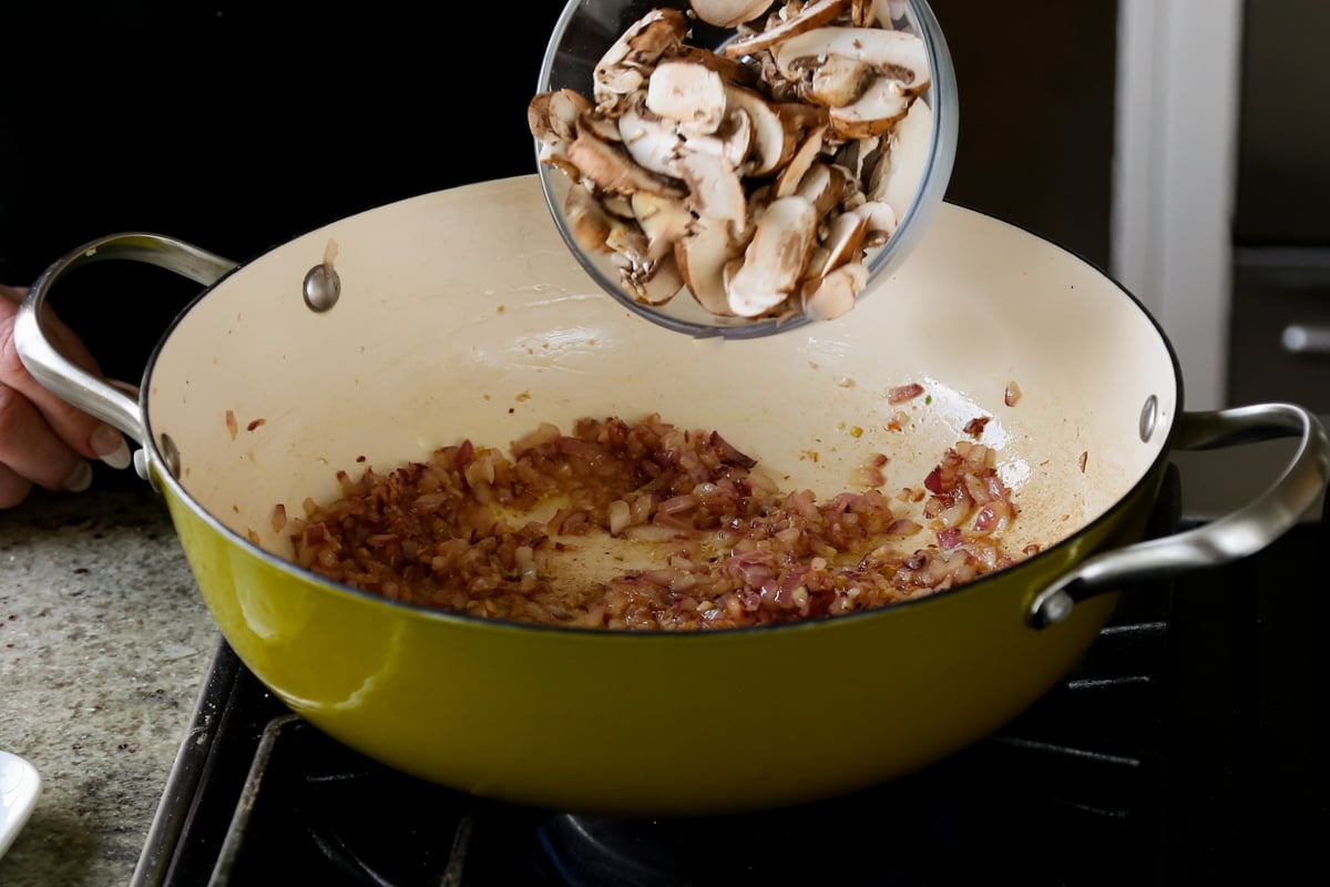 adding mushrooms to the cooked onion and garlic