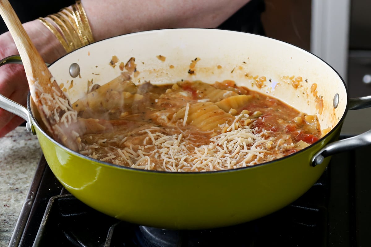 adding the vegan parmesan to the lasagna soup