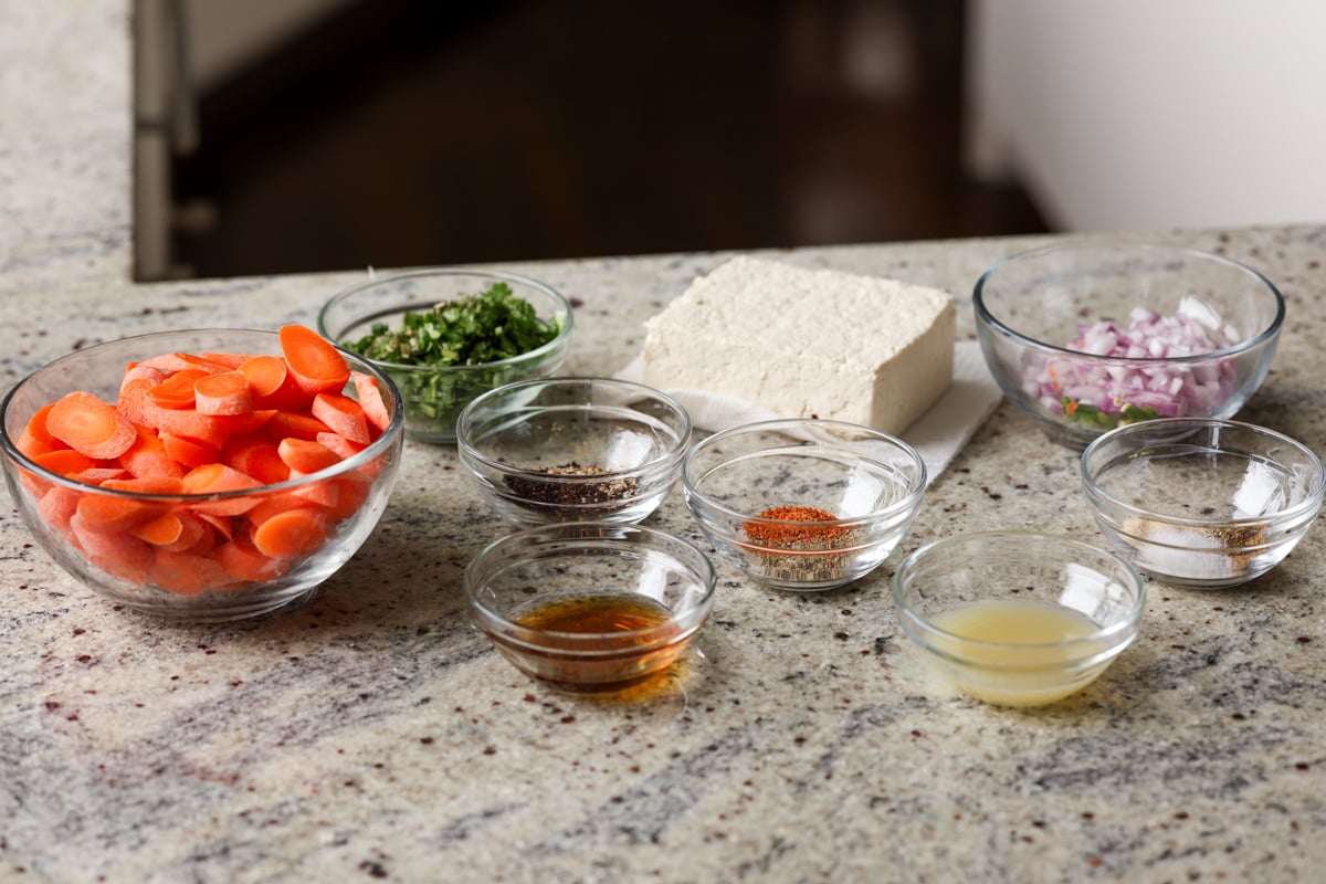 tofu and carrots ingredients in bowls on the kitchen counter