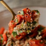 spooning a bite of shredded tofu topped with roasted carrots
