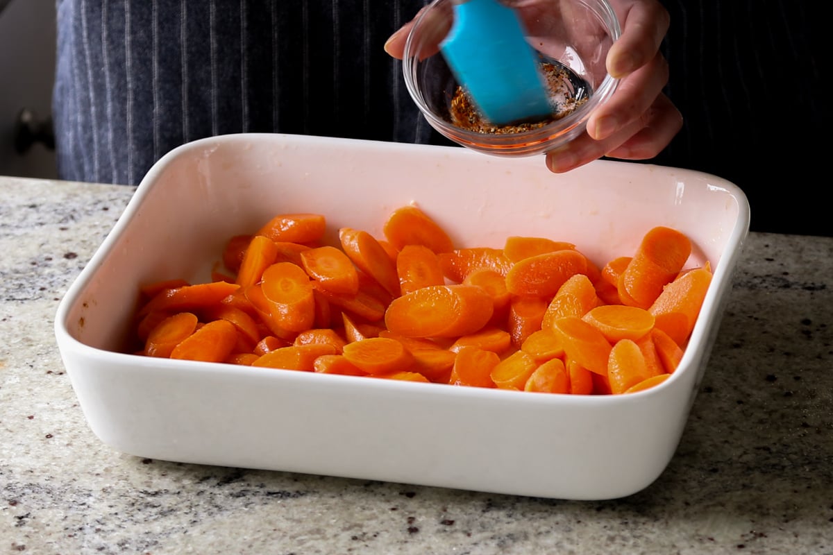 adding spices to the carrots