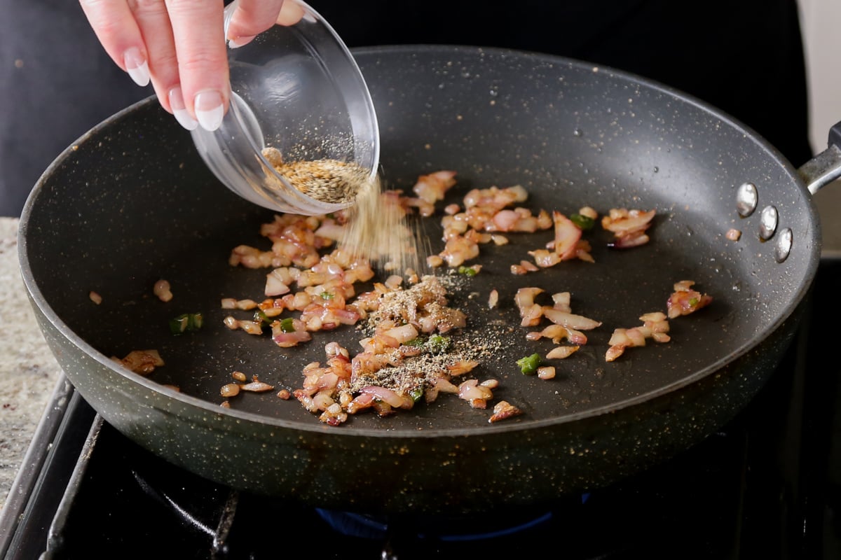 adding spices to the cooked onion in the pan