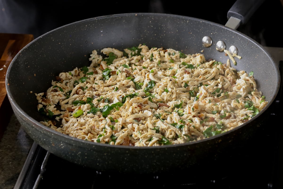 cilantro lime shredded tofu in a pan after tossing in the cilantro