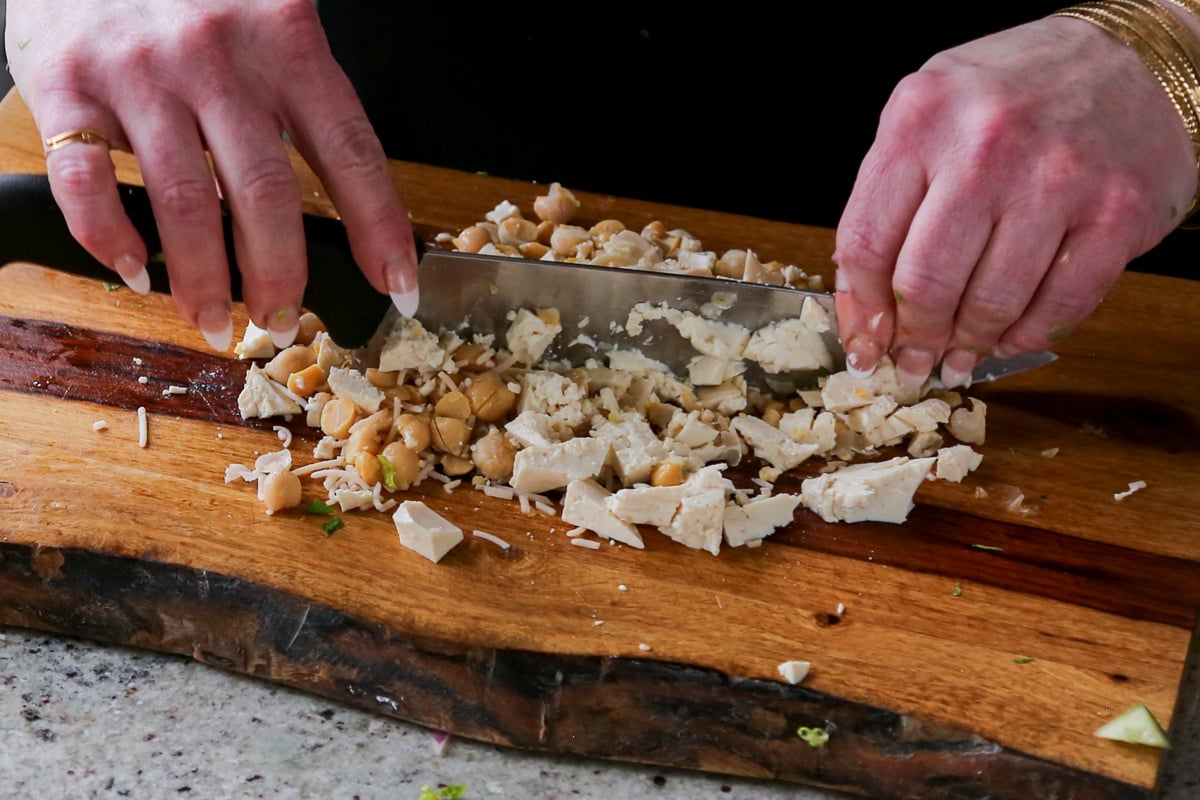 chopping the tofu, chickpeas, and vegan Parmesan