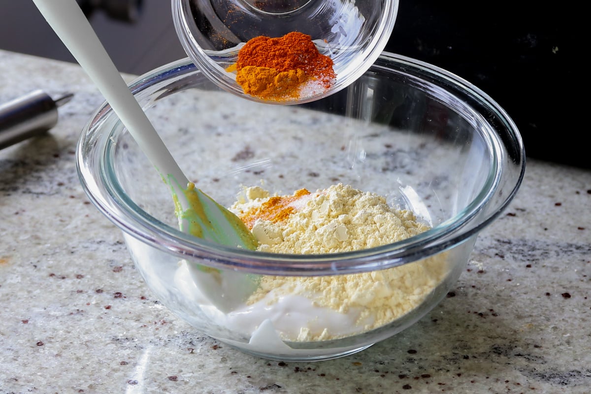 adding chickpea flour and spices to the yogurt