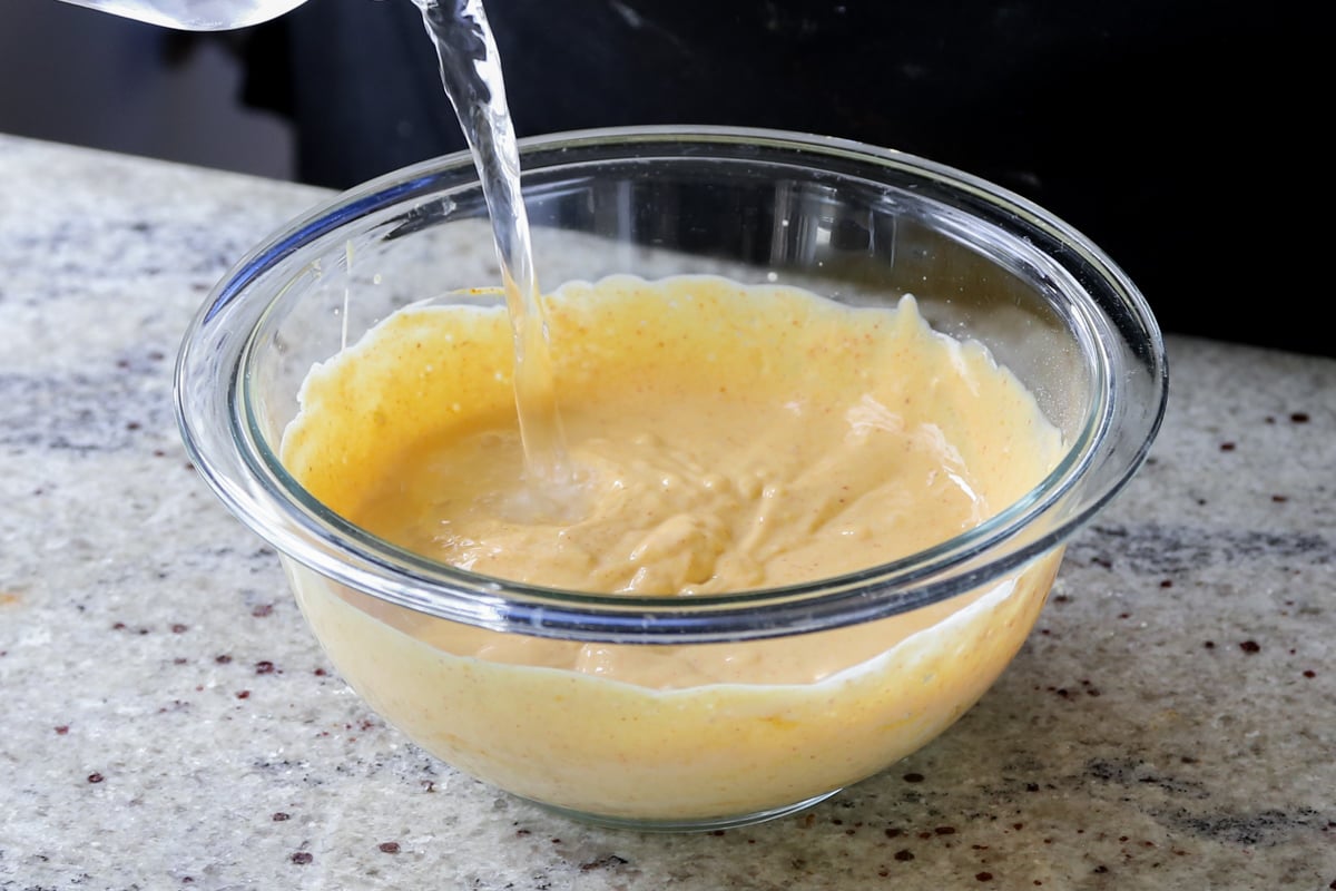 thinning the curry sauce in the bowl with some water