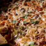 close-up of scooping up some orzo puttanesca from the pan