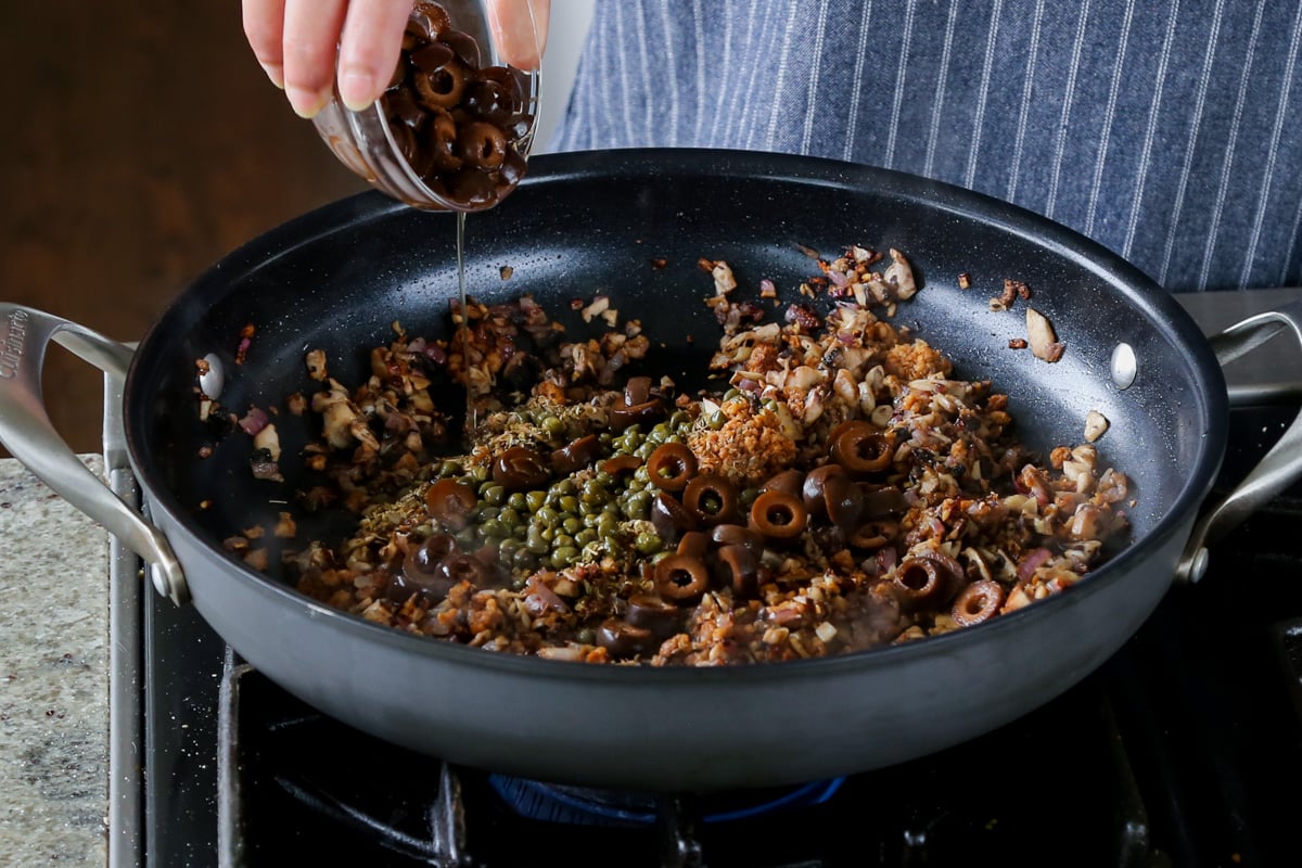 adding Kalamata olives and capers to the pan