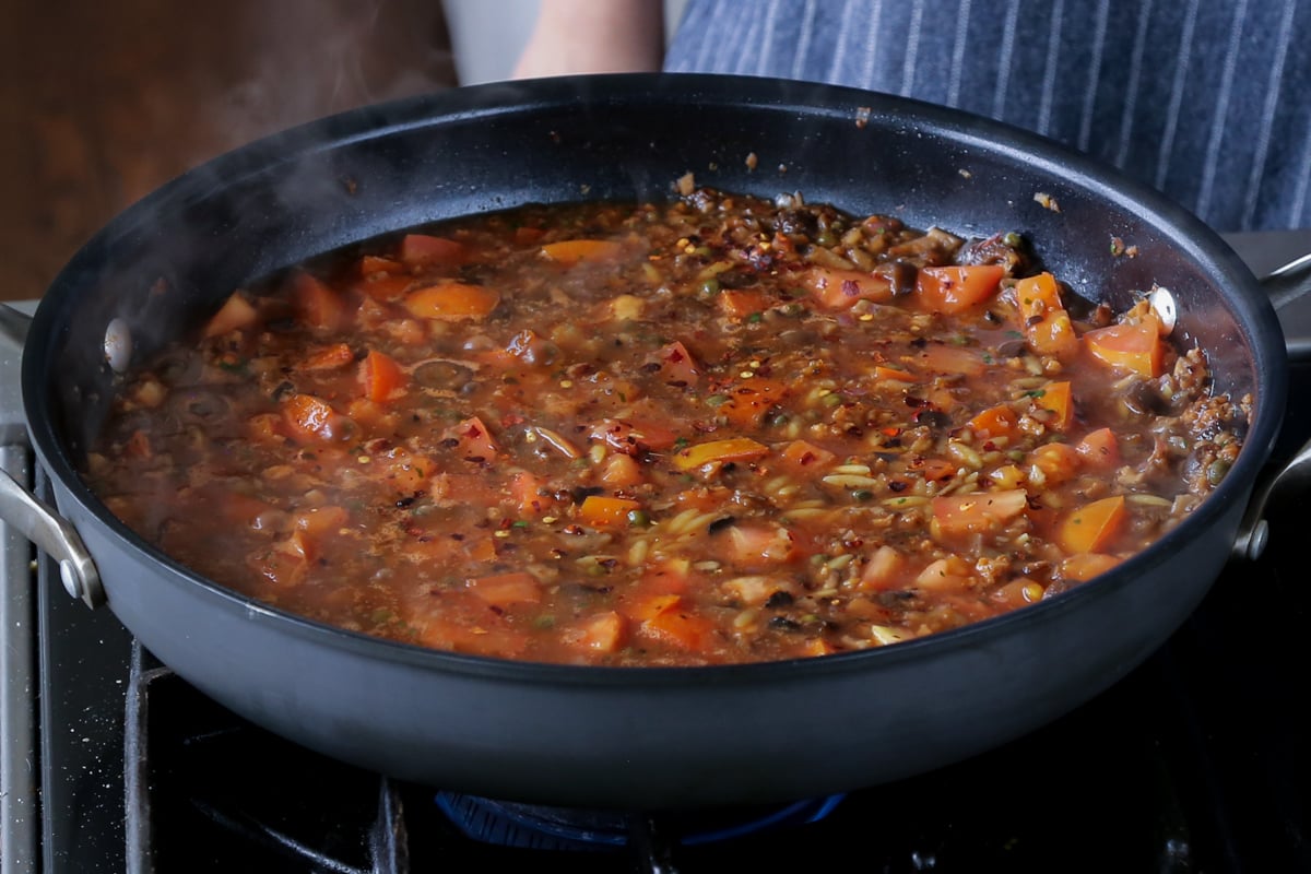 puttanesca sauce after stirring in the orzo