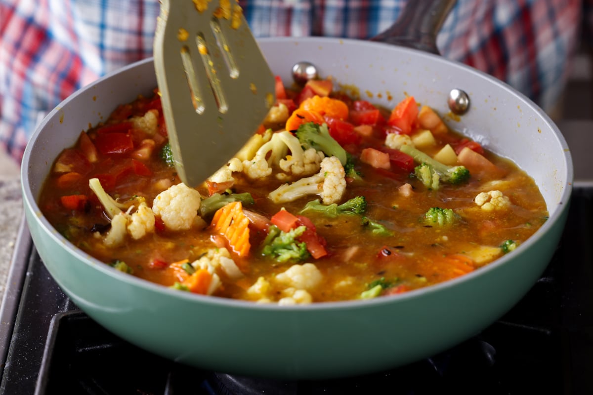 mixing in tomatoes and vegetables