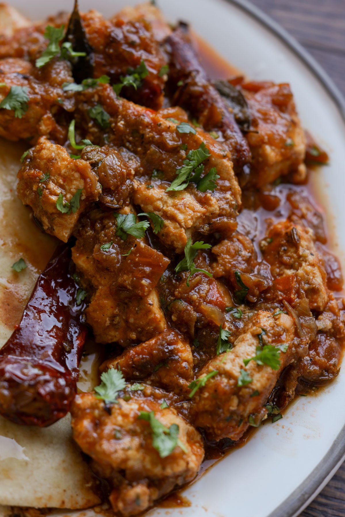 Chettinad pepper chicken curry on a plate with naan