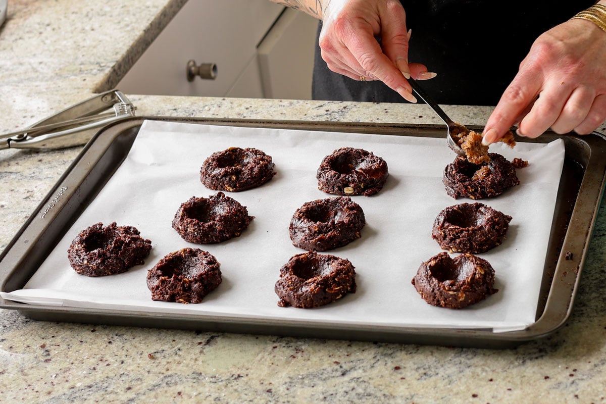 pressing wells into the centers of the unbaked German chocolate cookies