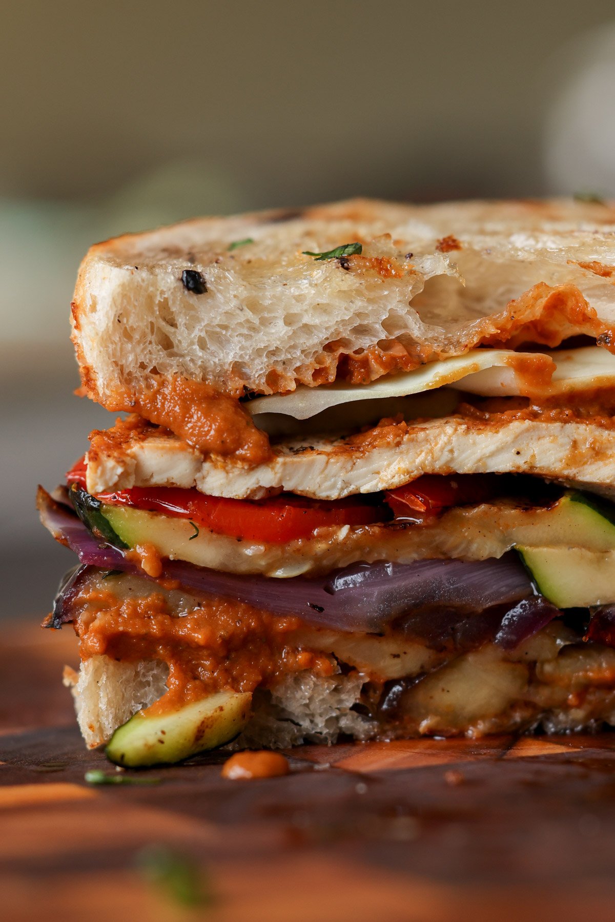 close-up of grilled veggie sandwich sliced in half on the cutting board