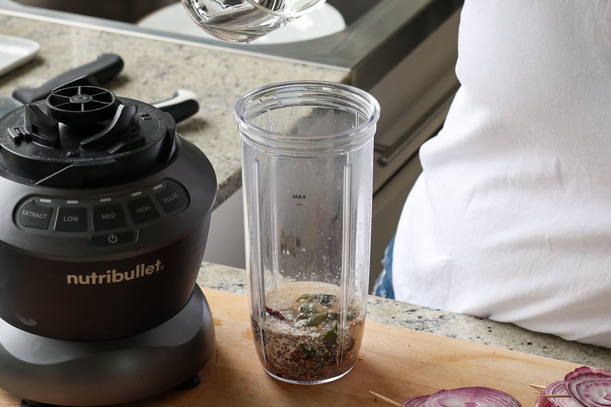 adding sun dried tomato spread ingredients to the blender