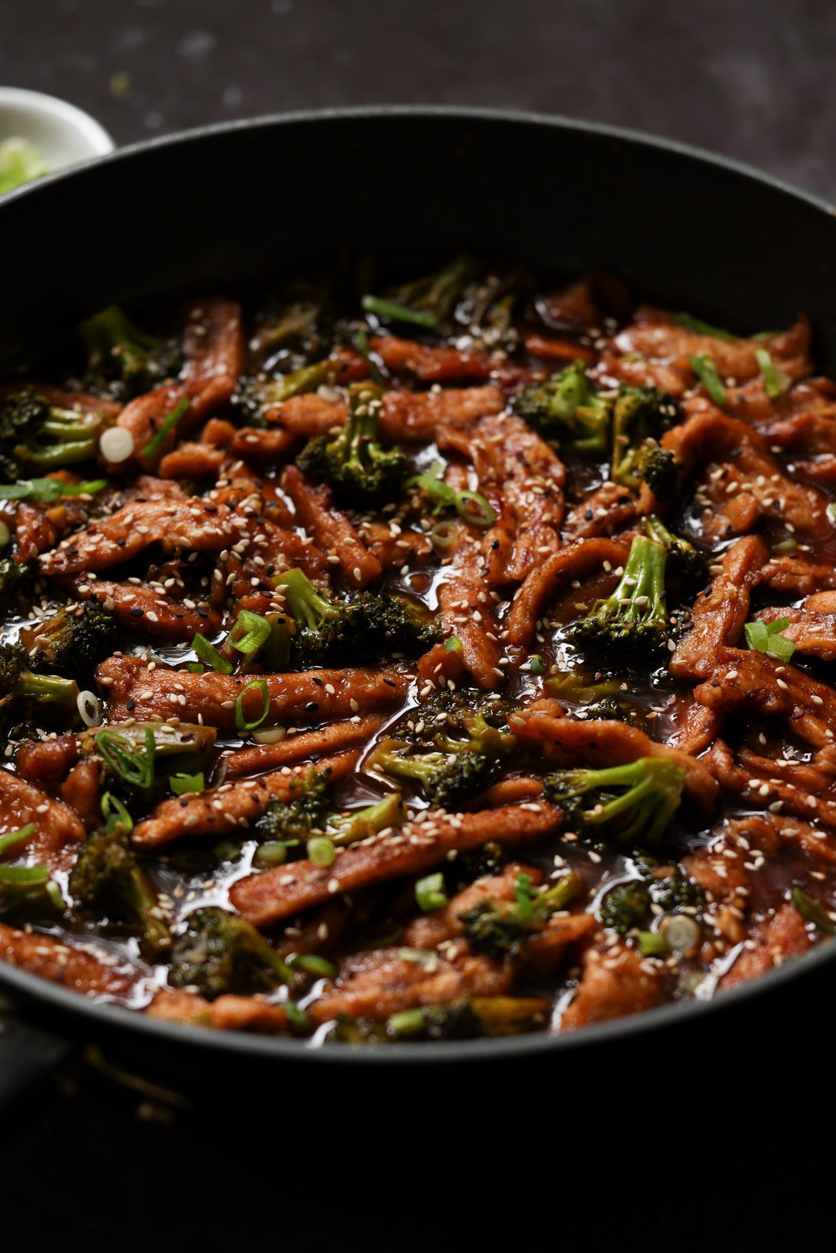 close-up of vegan beef with broccoli in the pan after adding garnishes