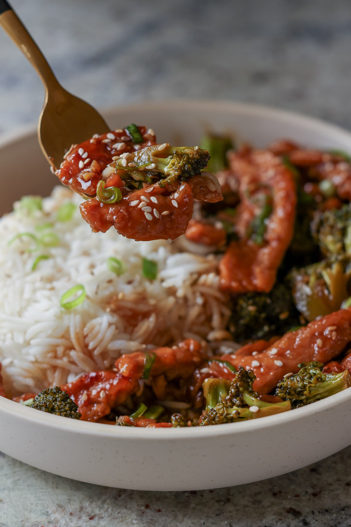 fork taking a bite of vegan beef with broccoli