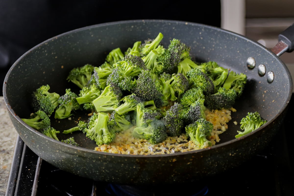 adding broccoli to the pan