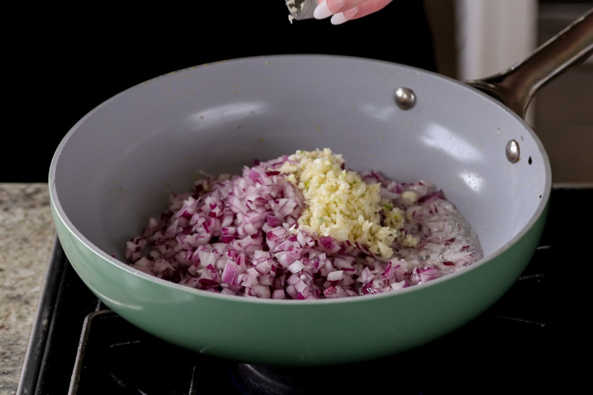 adding onion and garlic to the pan