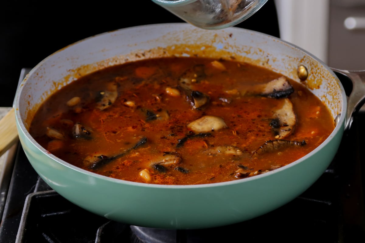 veggie bean stew in the pan after adding in the mushrooms
