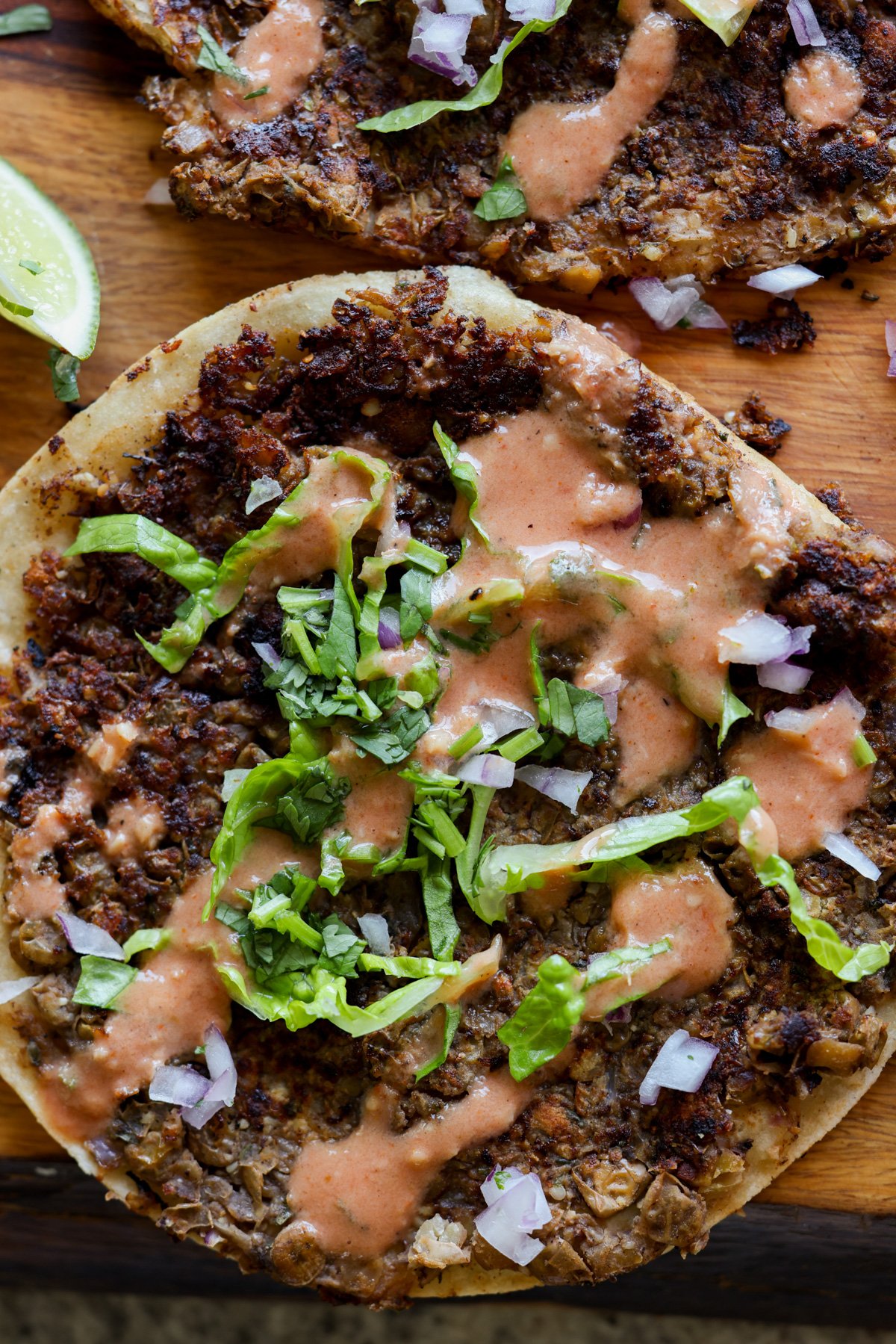 close-up of a vegan smash burger taco with butter chicken sauce