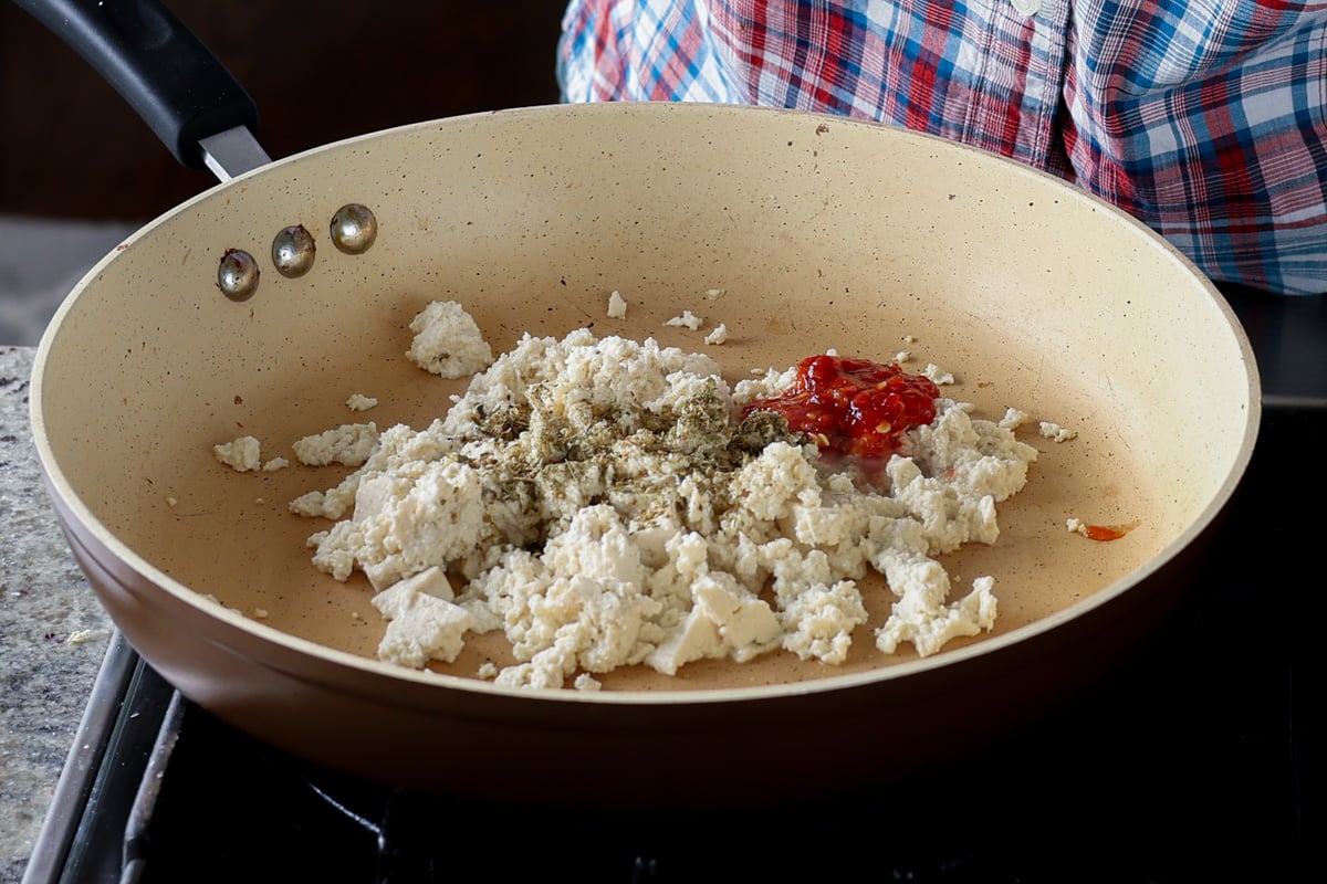 adding tofu crumble ingredients to the pan
