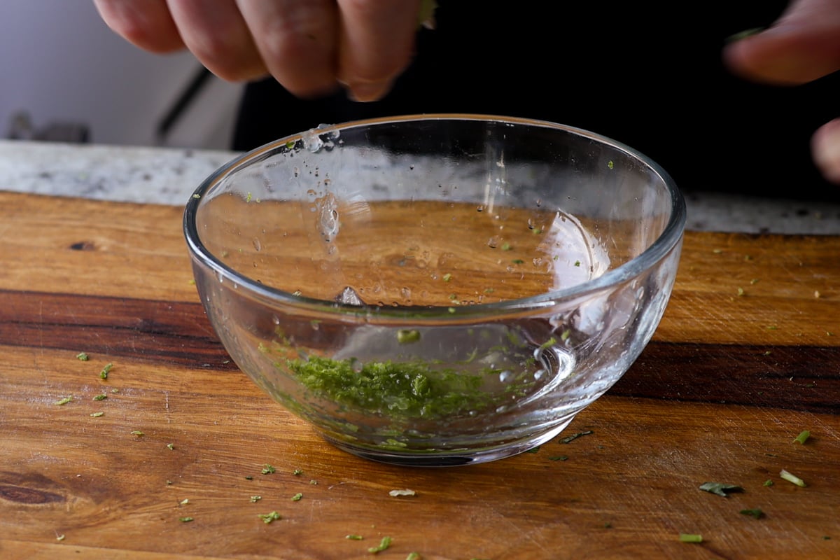 adding lime juice to the lime zest in a bowl