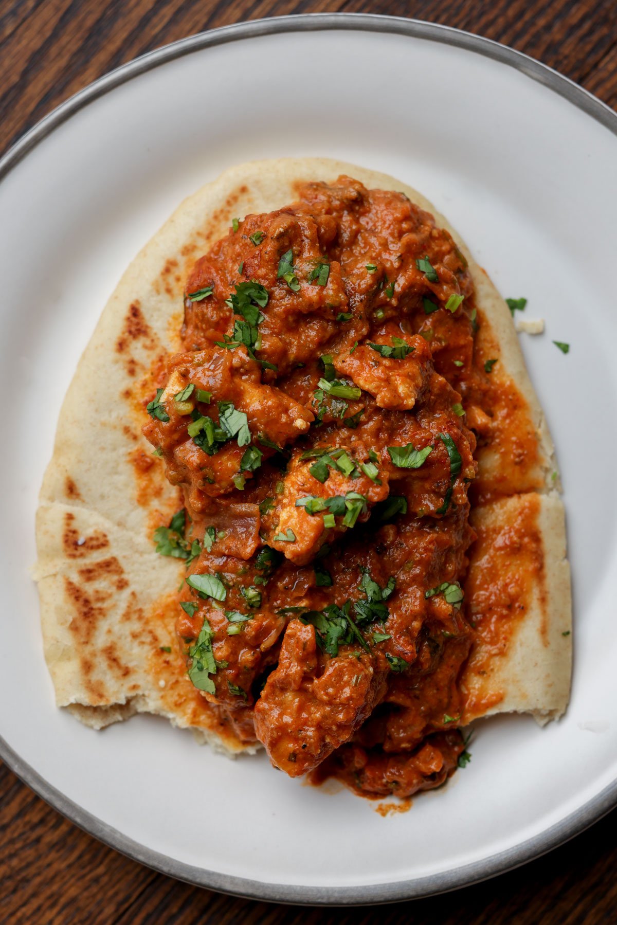 flatbread with chicken angara on top on a plate
