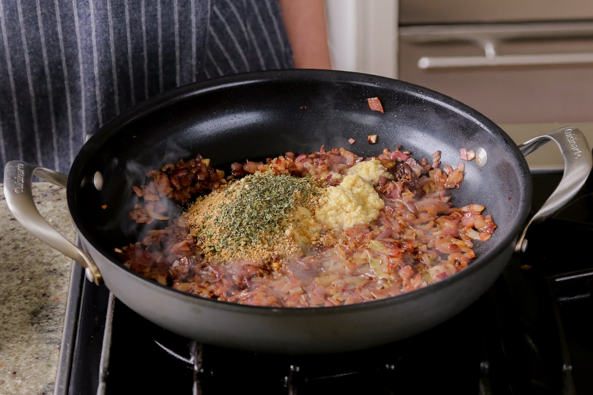 adding spices and more aromatics to the cooked onion