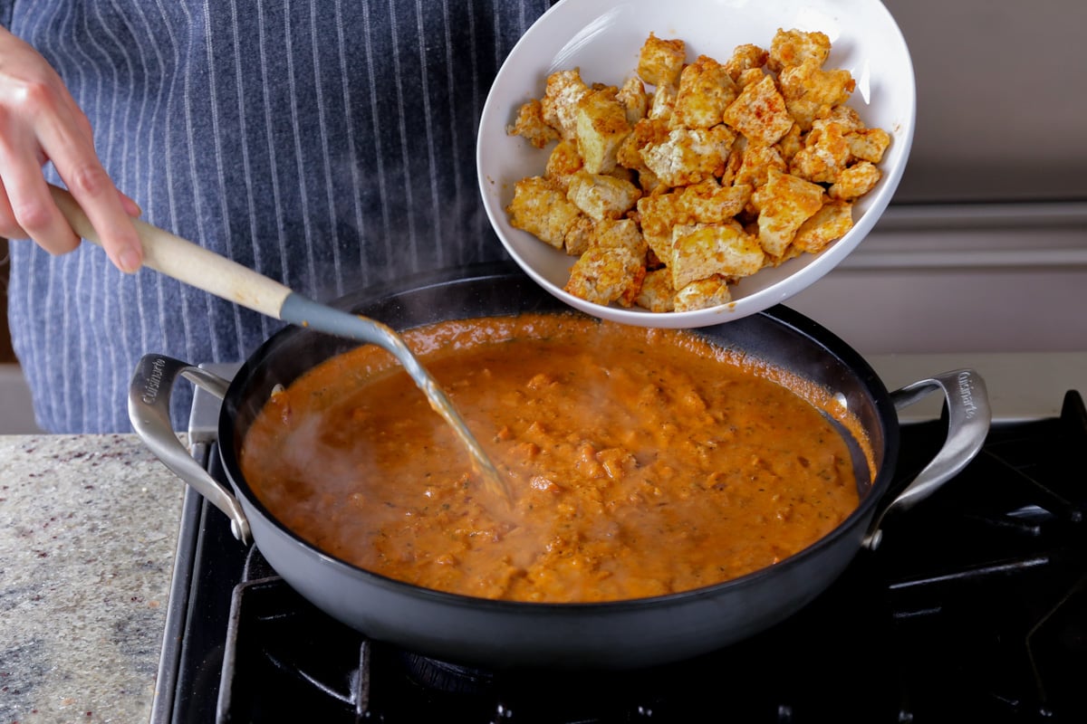 adding tofu to the angara curry sauce
