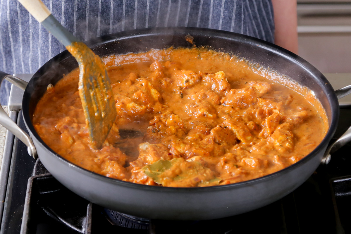 mixing tofu into the angara curry sauce