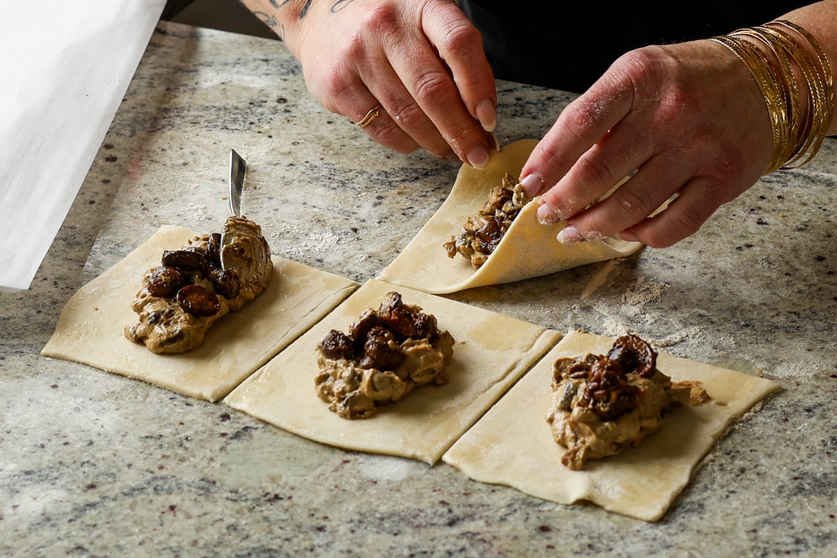 folding the creamy and sautéed mushrooms into the puff pastry
