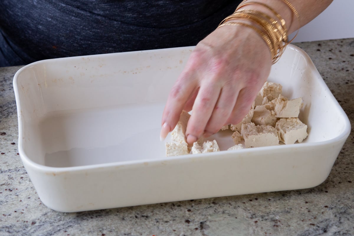 adding tofu to the pan
