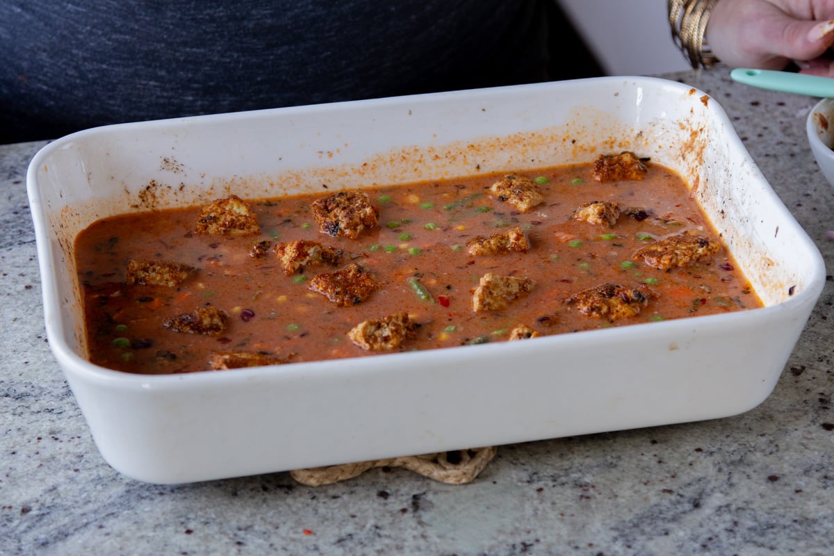 adding tofu back to the top of the tikka masala rice in the baking pan