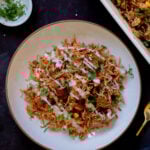 plate of tikka masala rice topped with yogurt and cilantro