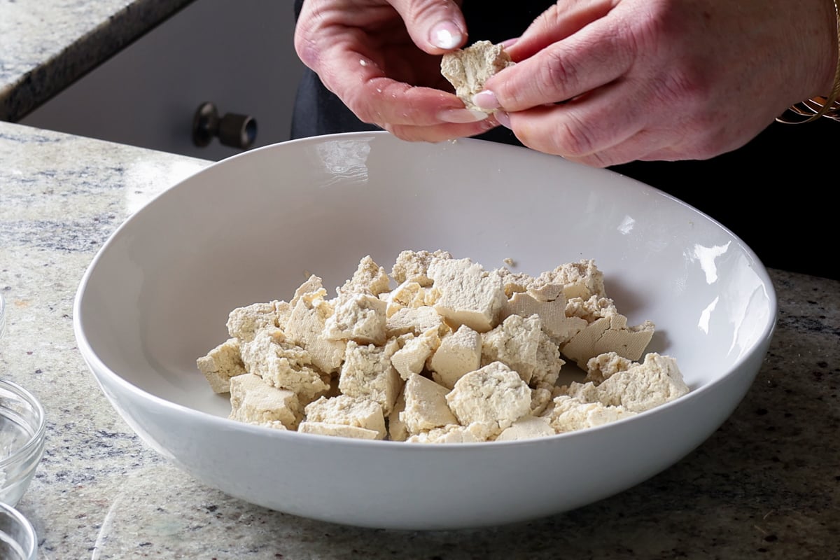 tearing the tofu into pieces