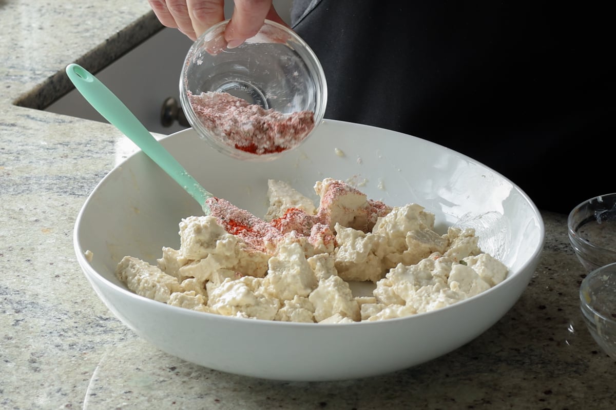 adding cornstarch and spices to the tofu