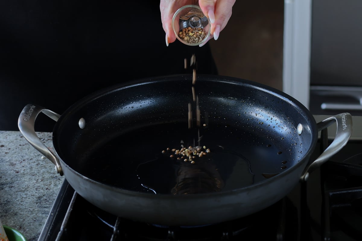 adding whole spices to the pan