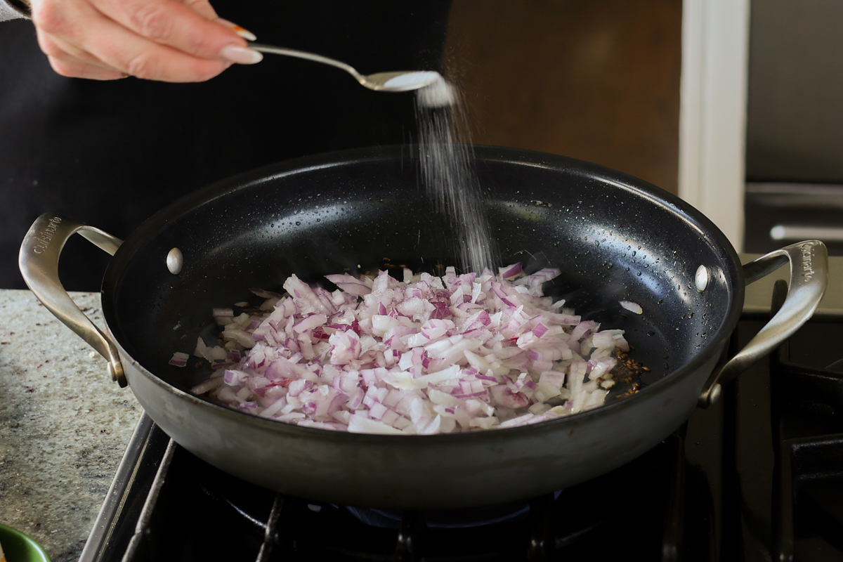 adding salt to the onion