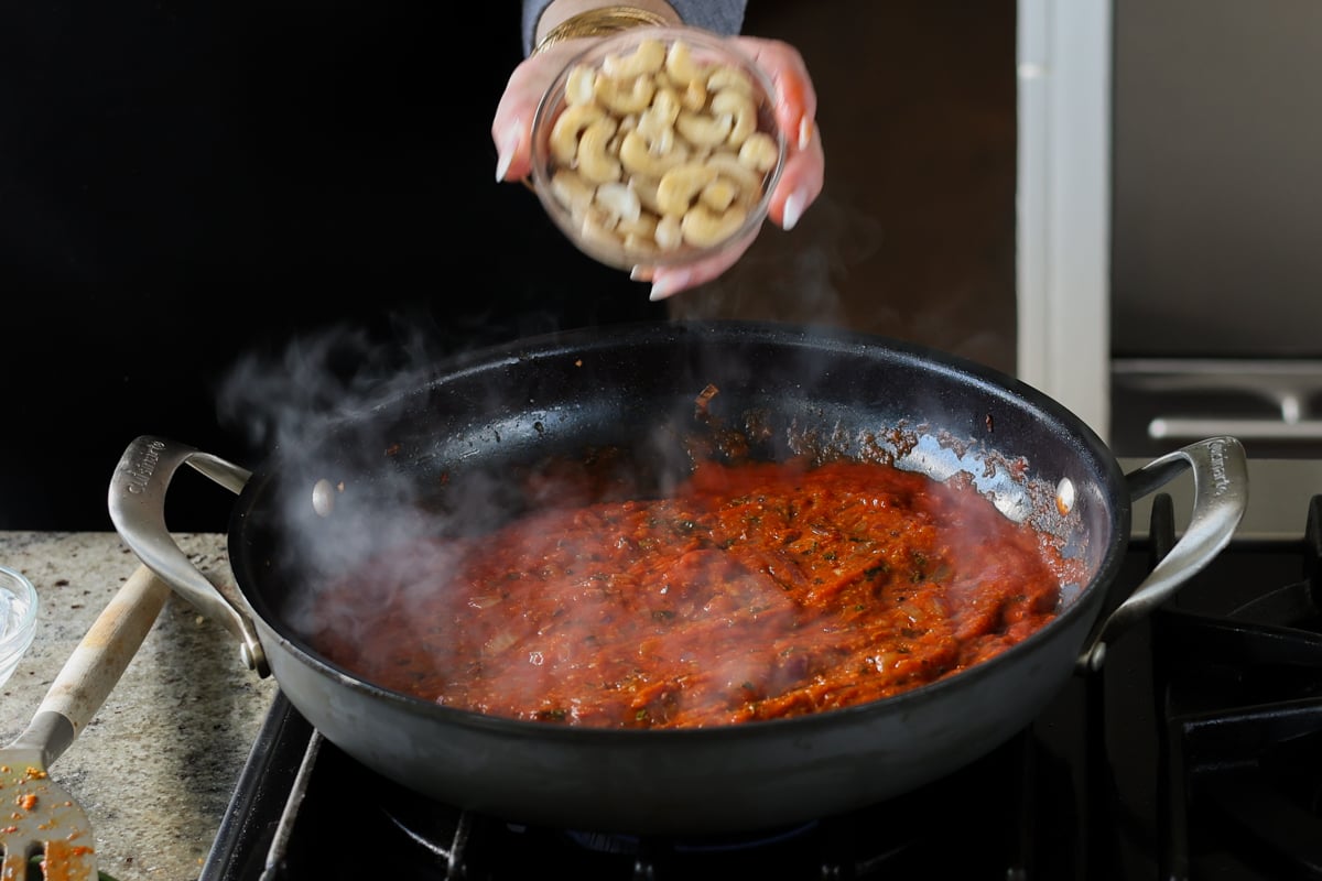 adding cashews to the sauce