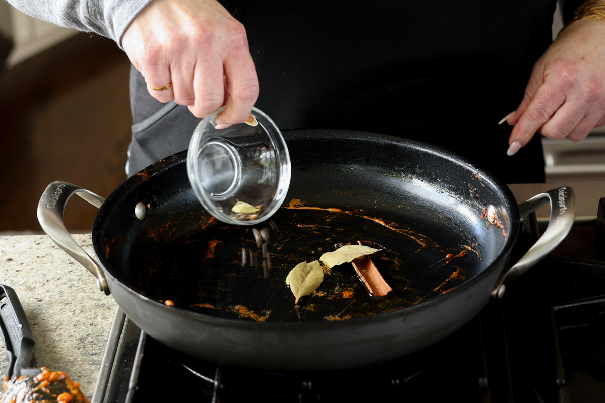 adding more whole spices to the pan