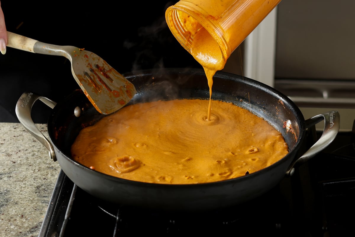 adding the blended sauce back to the pan