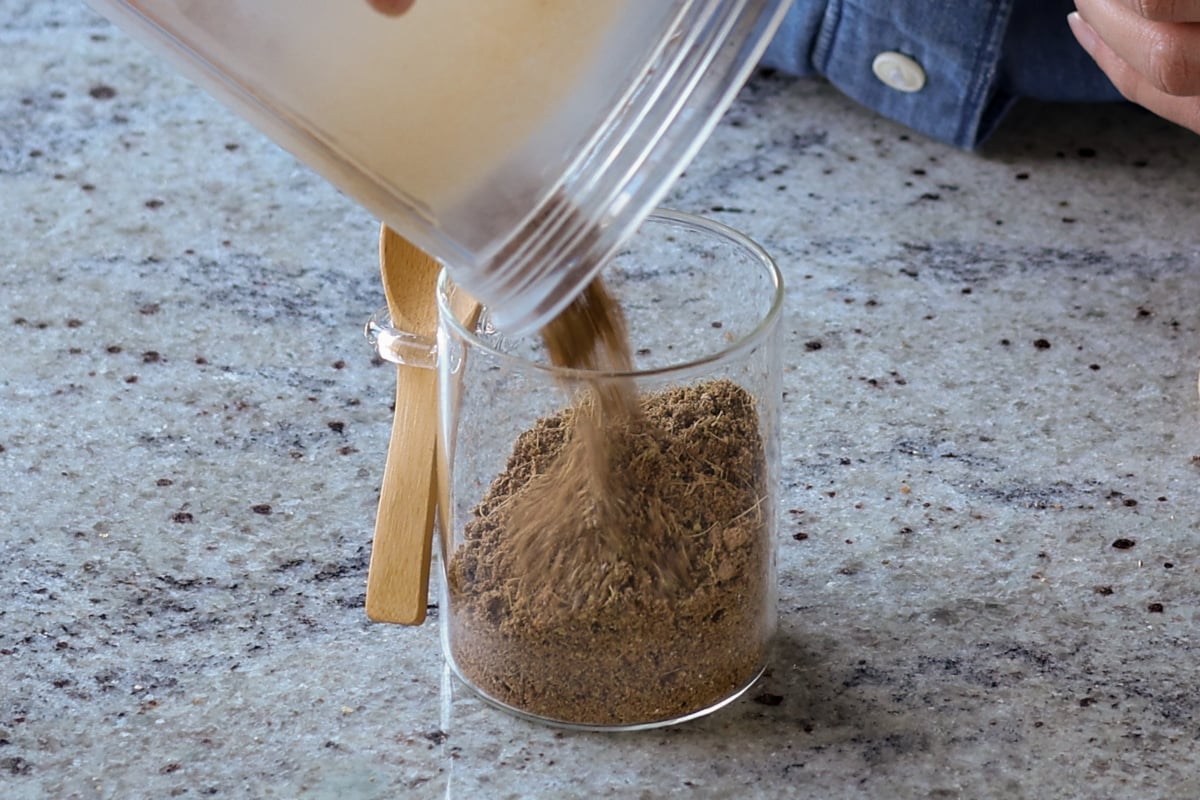 pouring chai spice mix into a jar